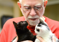 Photo of a man holding two kittens. Link to Life Stage Gift Planner Over Age 65 Gifts. over 65.jpg